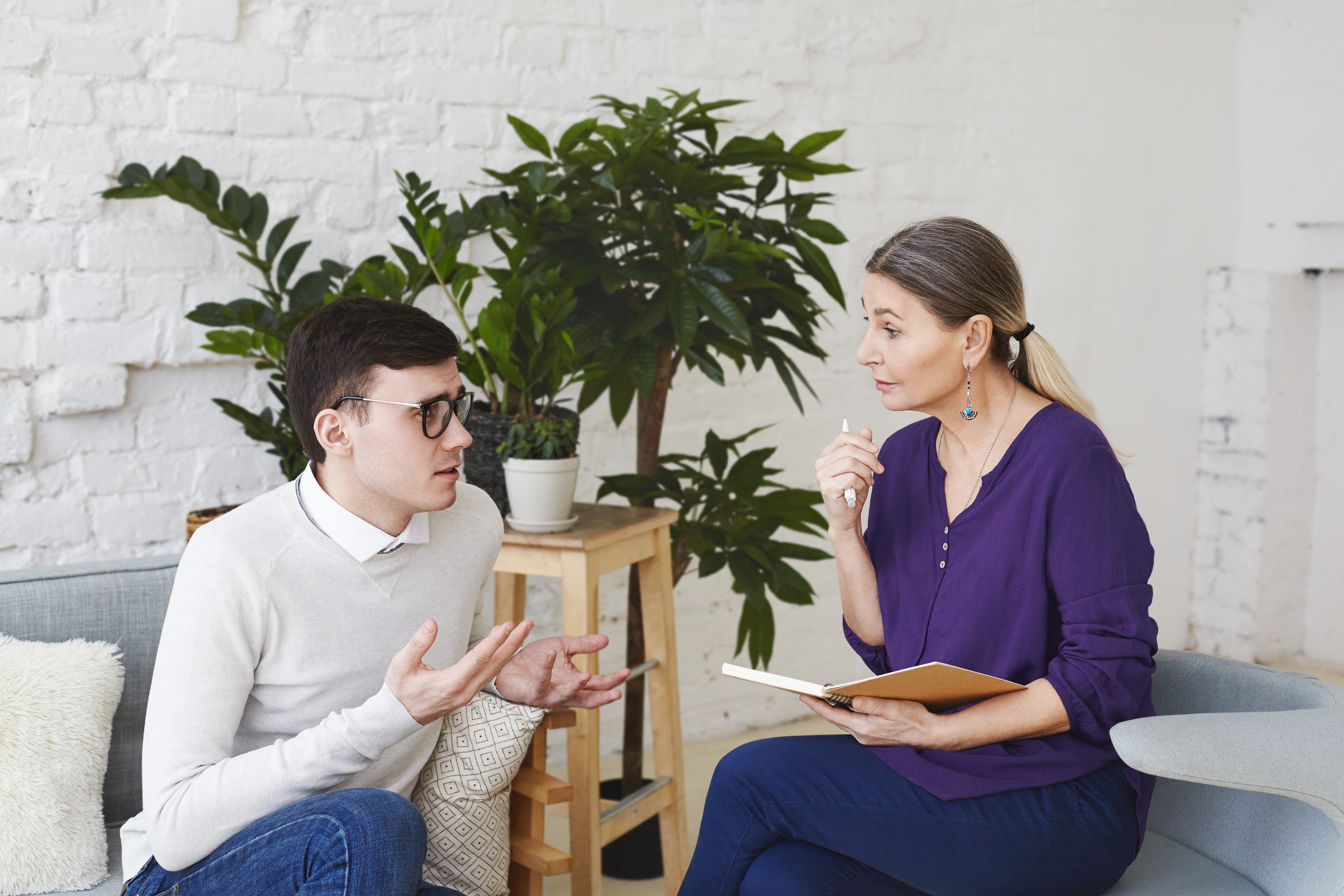 Man and woman seated and conversating in an office setting