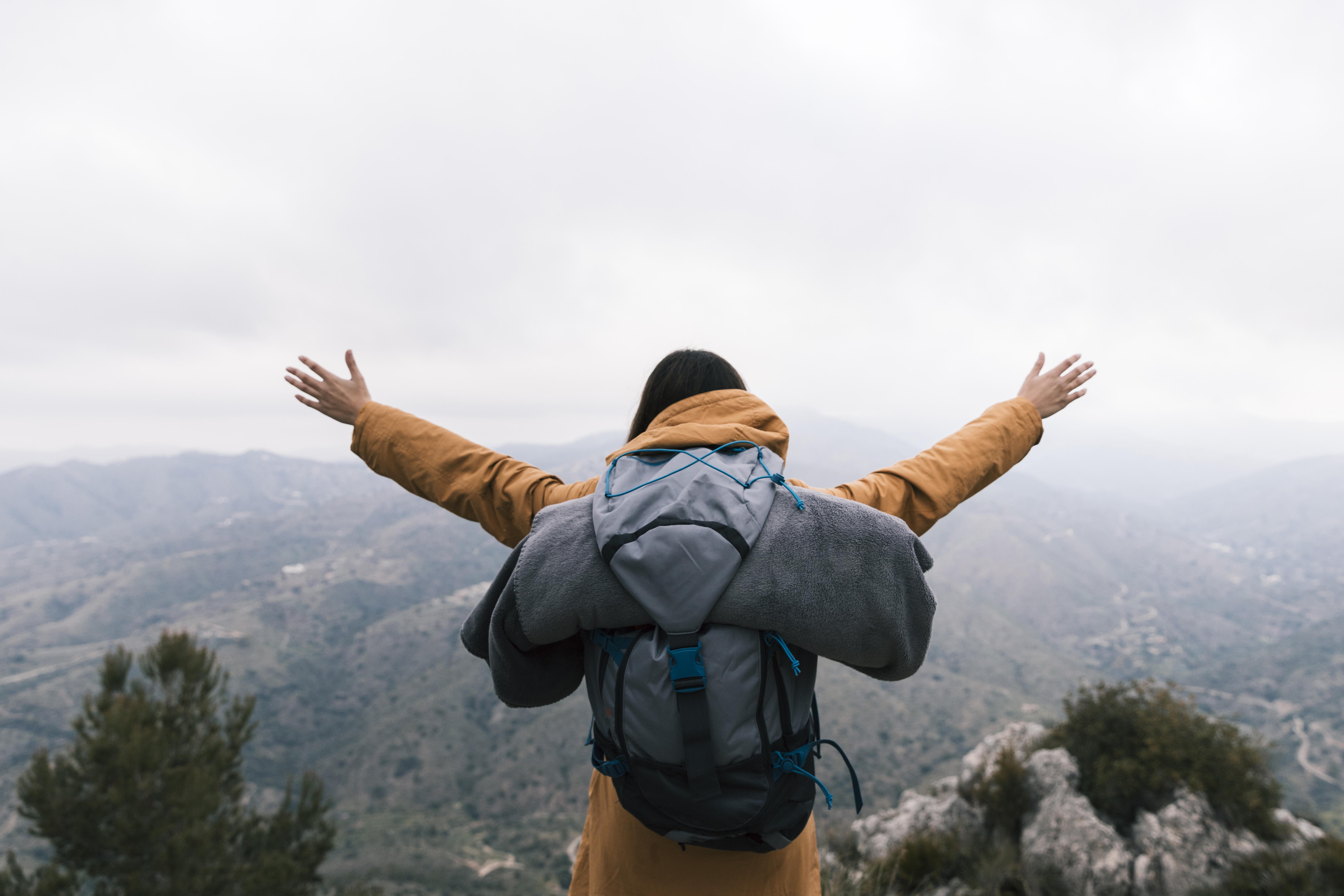 Man raising arms atop a mountain